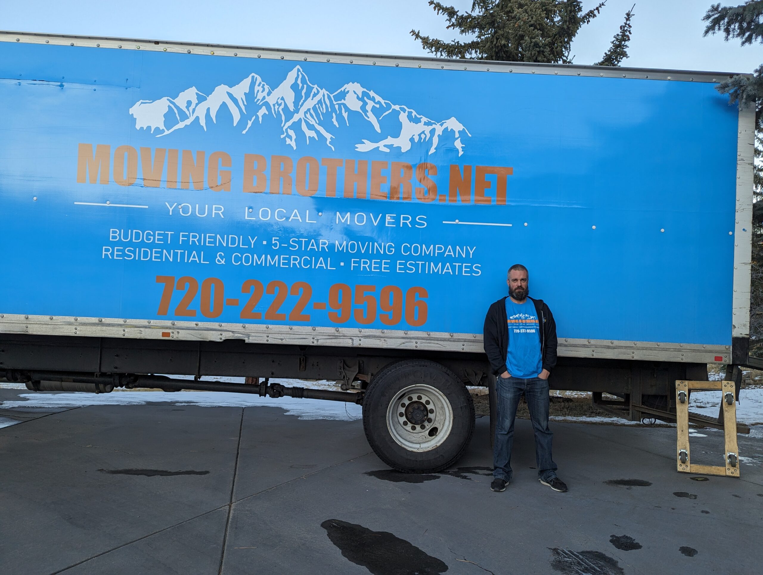 Moving Brothers' truck parked outside with staff.